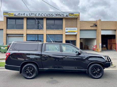Black utes for sale parked in front of a 4x4 accessories shop