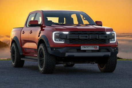 Red Ford Ranger with NextGen Ranger Accessories for enhanced performance on a scenic road at sunset.