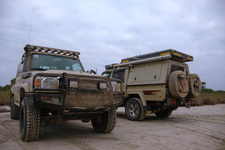 Off-road vehicles equipped with canopy roof bars for enhanced carrying capacity on a rugged terrain.