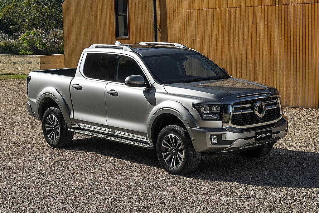 GWM Cannon Alpha Ute parked in front of a modern building, showcasing its robust design and appealing to 4x4 enthusiasts.