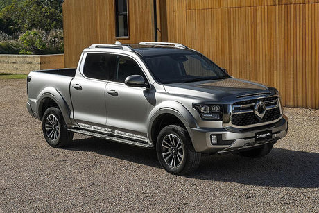 GWM Cannon Alpha Ute parked in front of a modern building, showcasing its robust design and appealing to 4x4 enthusiasts.
