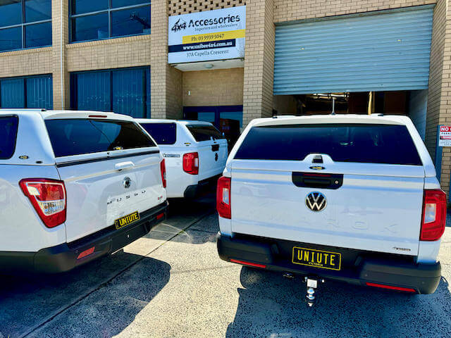 Various canopies for Volkswagen Amarok trucks displayed at an accessory shop, showcasing design options for Amarok owners.