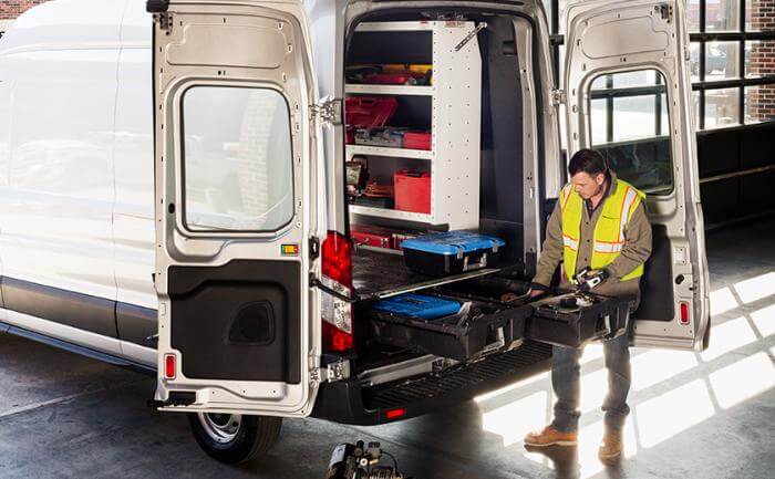 Worker using DECKED DRAWER storage solution in van for organized equipment storage and accessibility, optimizing space efficiently.