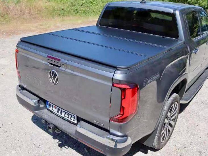 Truck with black hard bed cover parked outdoors.