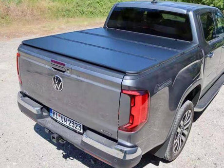 Truck with black hard bed cover parked outdoors.