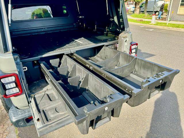 Car drawers installed in the back of a vehicle for organized storage and easy access to items while traveling.