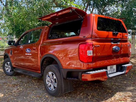 Orange truck equipped with an ARB Canopy for off-road adventures