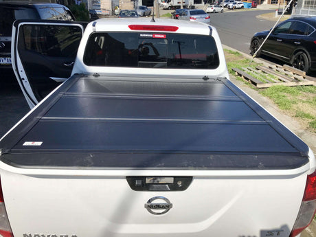 Truck with QUAD-FOLD TONNEAU COVERS installed, showcasing the sleek design and durability on a sunny day.