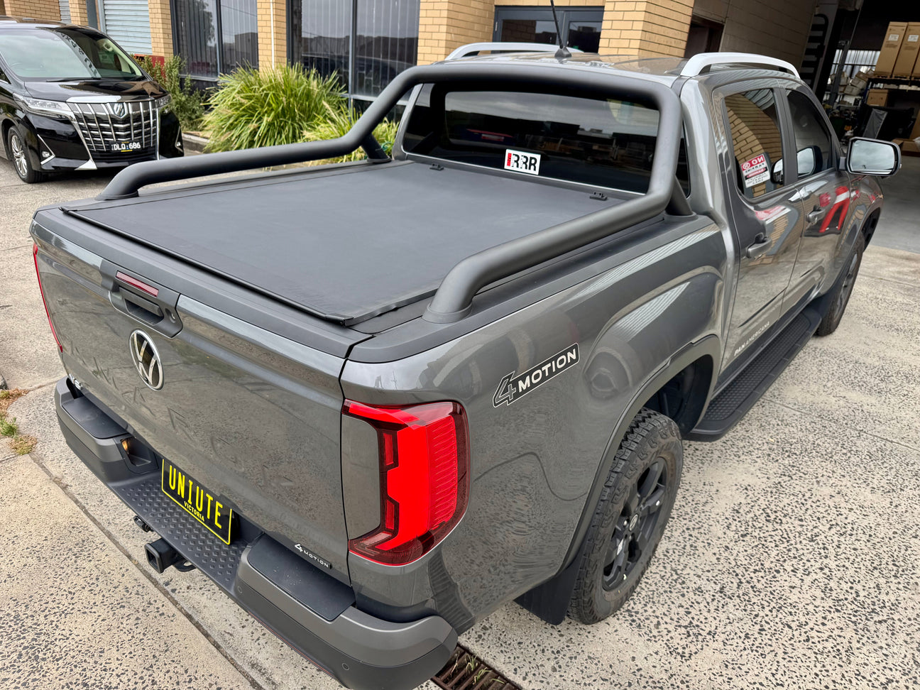 Silver 4x4 ute with REVOLVER ROLL UP COVERS for enhanced security and style on a desert landscape.