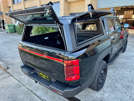 Stainless steel canopy on BYD Shark 6 — roof rail showing 150kg rated capacity