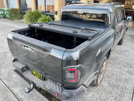 KIA Tasman hard lid tri-fold — panel open showing tub access
