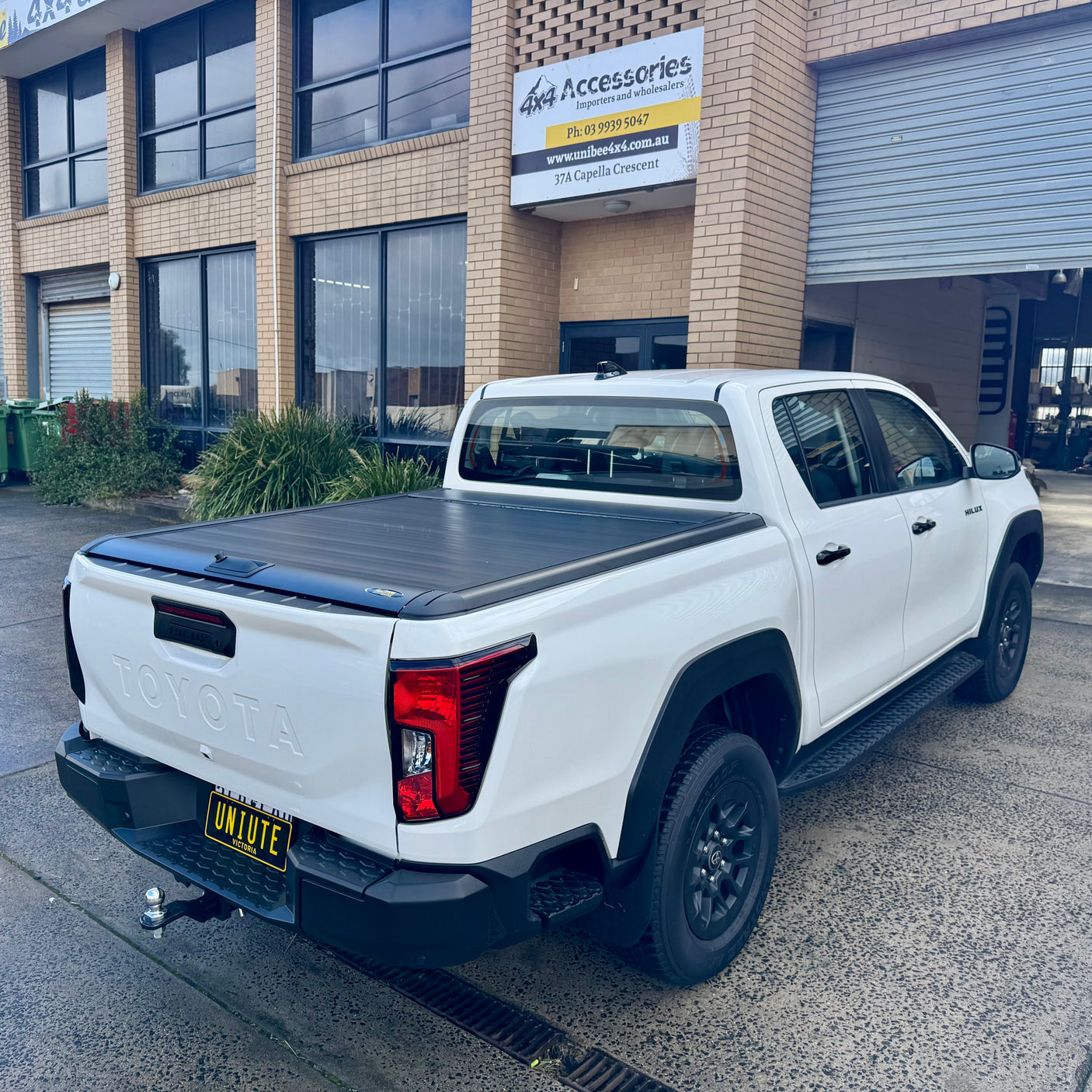 UniUte manual roller shutter on Toyota Hilux N90 — parked outdoors rear view