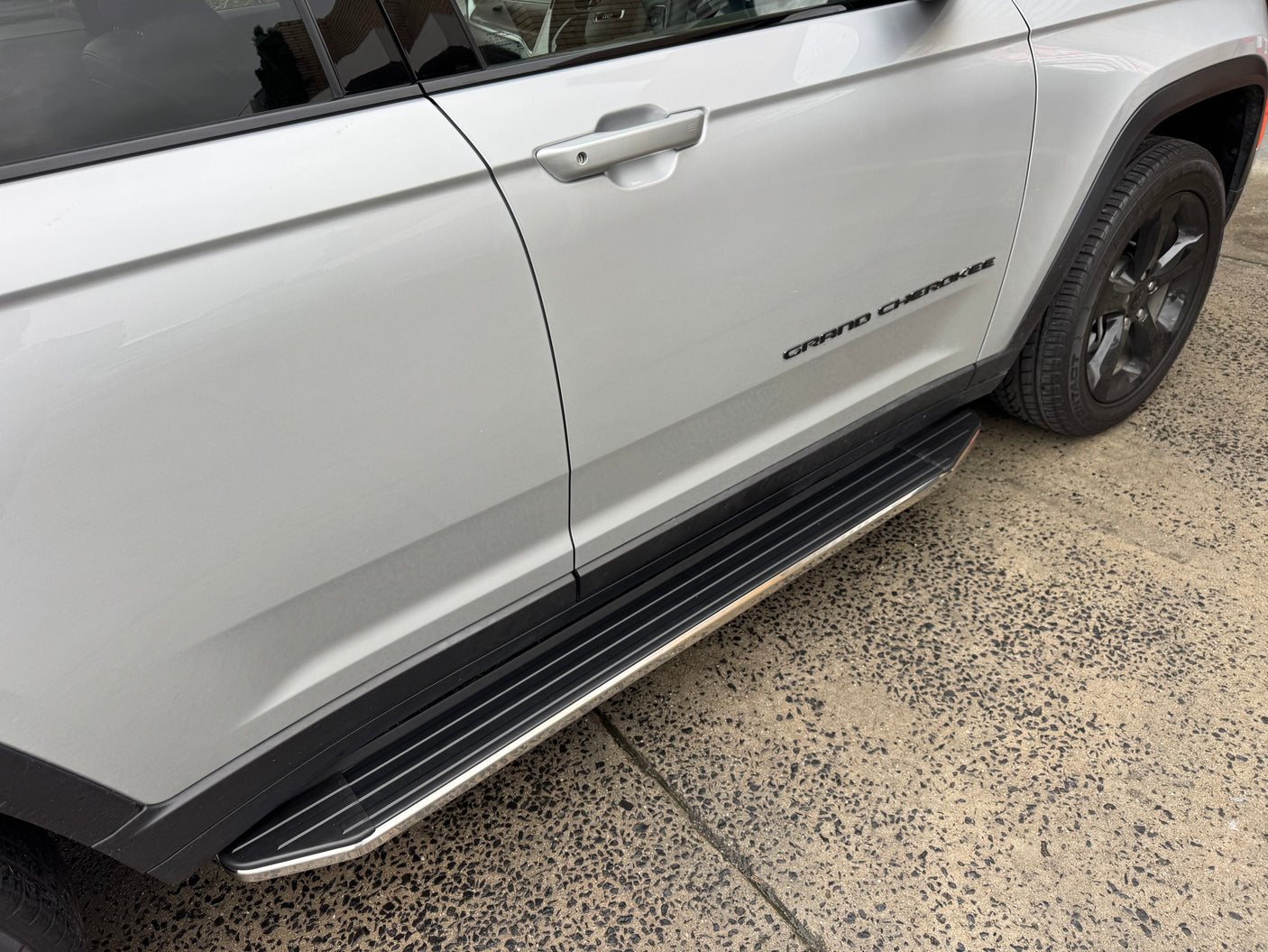 Grand Cherokee WL L side steps — close-up of the non-slip step pad and mounting bracket