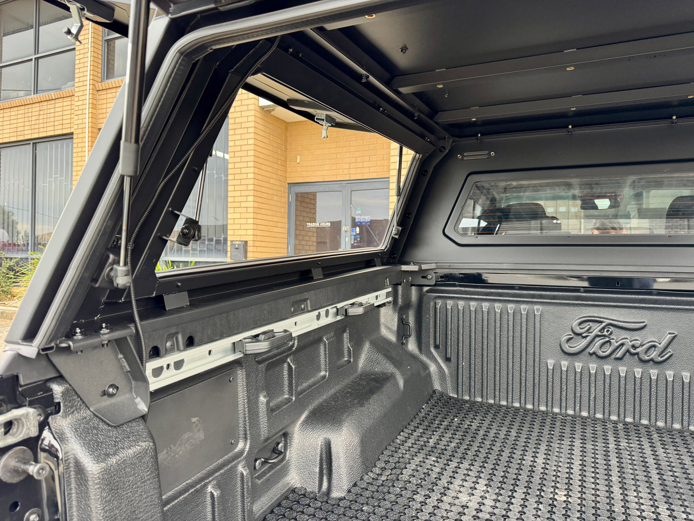Stainless steel canopy on Ford Ranger NextGen — driver-side view with the side window closed