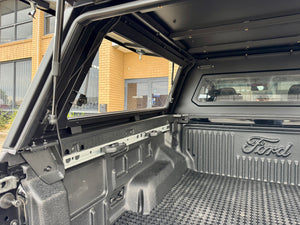 Stainless steel canopy on Ford Ranger NextGen — driver-side view with the side window closed
