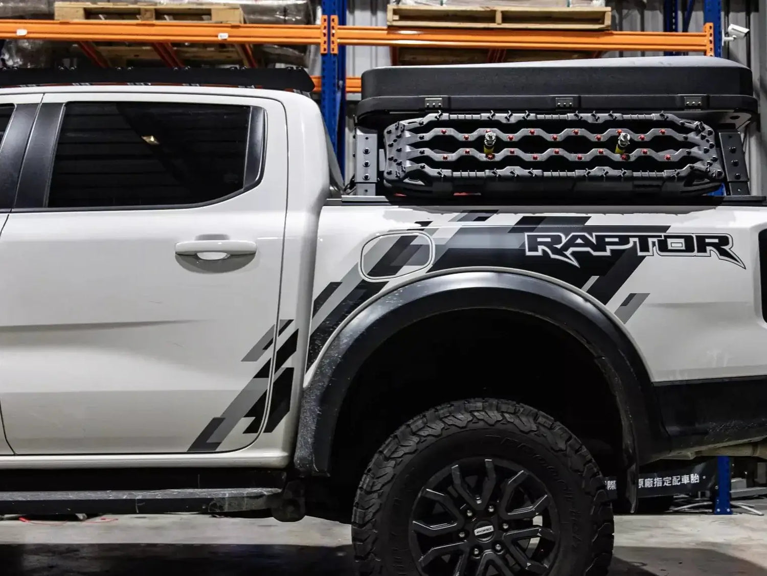 Tub rack carrier on pickup truck loaded with gear and accessories outdoors.