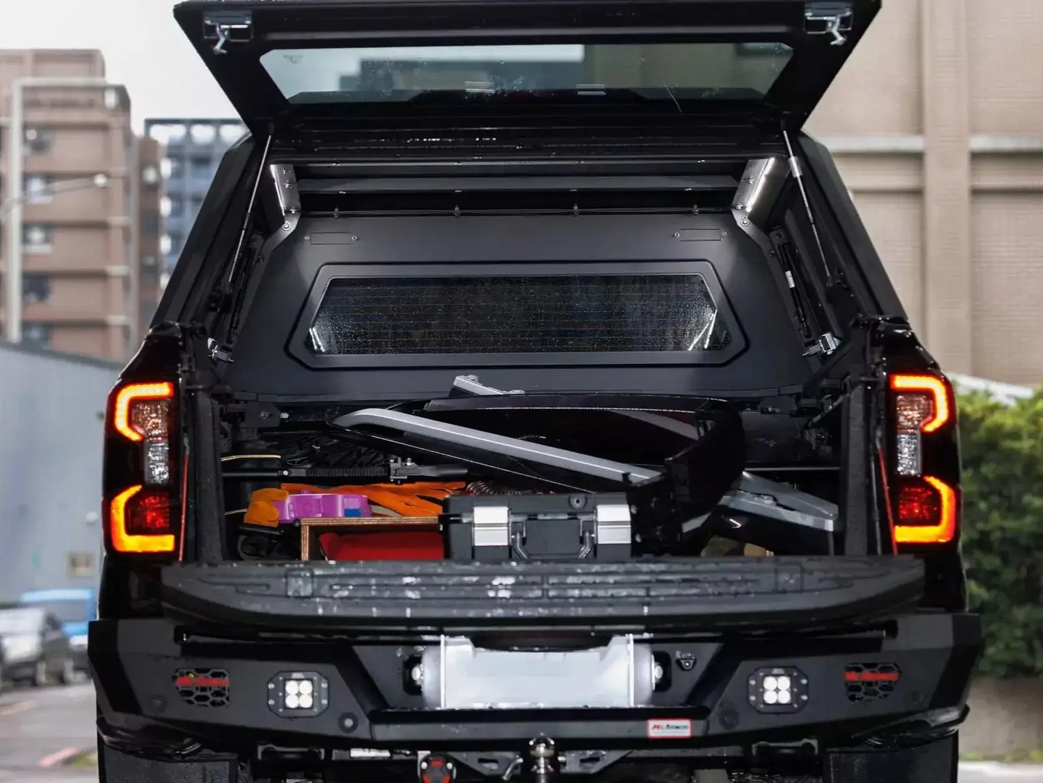 Stainless steel canopy ford ranger NextGen 2023+ with open tailgate showcasing storage capacity and durability in urban setting.