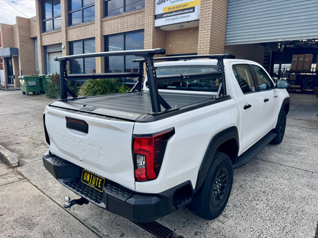 Heavy duty aluminium ladder rack — three-quarter rear view installed on black ute