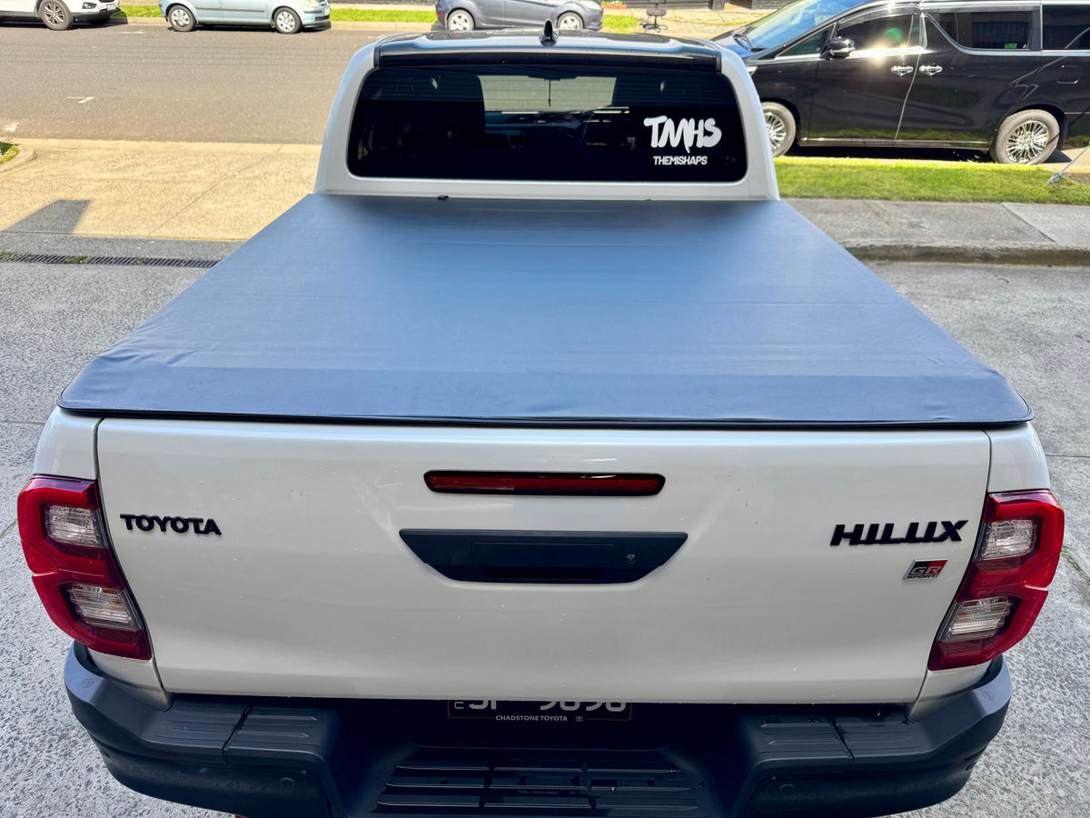 Toyota Hilux N80 N90 with soft roll-up cover — side view showing rolled position