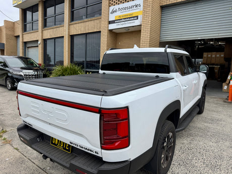 BYD Shark 6 tub cover with Quad-Fold Hard Tonneau Cover for 2025 models on a concrete driveway
