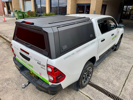 Toyota Hilux 2015–2026 stainless steel canopy — rear three-quarter view showing door and finish