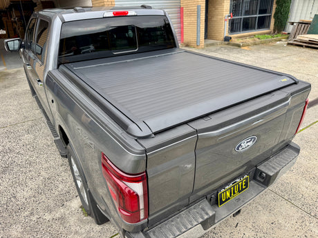 Electric roller shutter on Ford F-150 — side profile showing low-profile aluminium slats