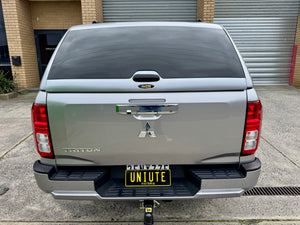 Triton MV fibreglass canopy — rear three-quarter view showing the door and finish