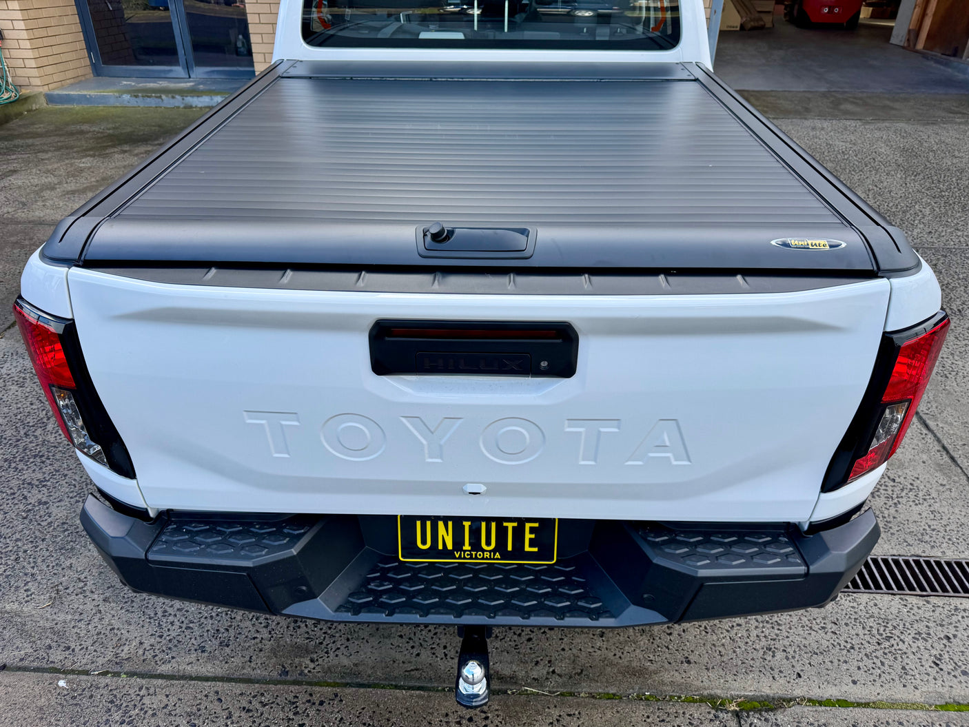 Toyota Hilux N90 2026+ with UniUte roller shutter — three-quarter rear view closed