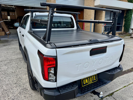 Aluminium ladder rack on roller cover — side view showing bar spread and load position