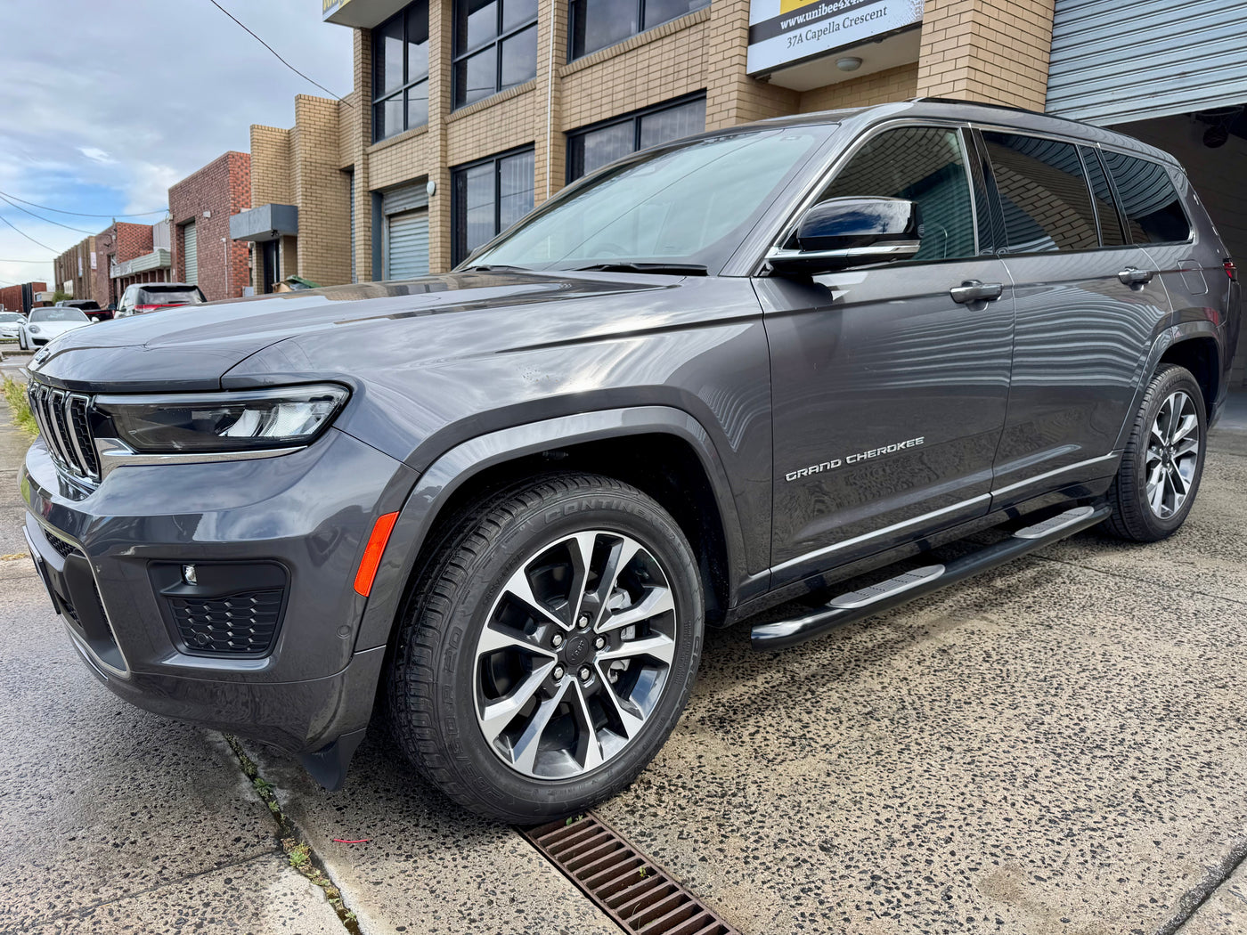 Black side bars on Jeep Grand Cherokee — rear door step view showing fitment