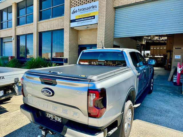 Ford Ranger with UniUte ranger roller shutter parked outside 4x4 accessories shop.
