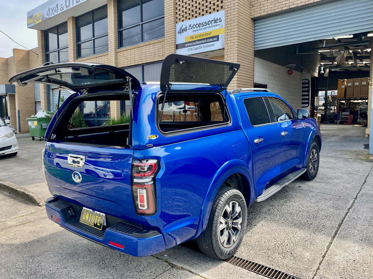 Blue GWM Cannon canopy, 2020-2025 model, parked outside a workshop, showcasing enhanced design and functionality.