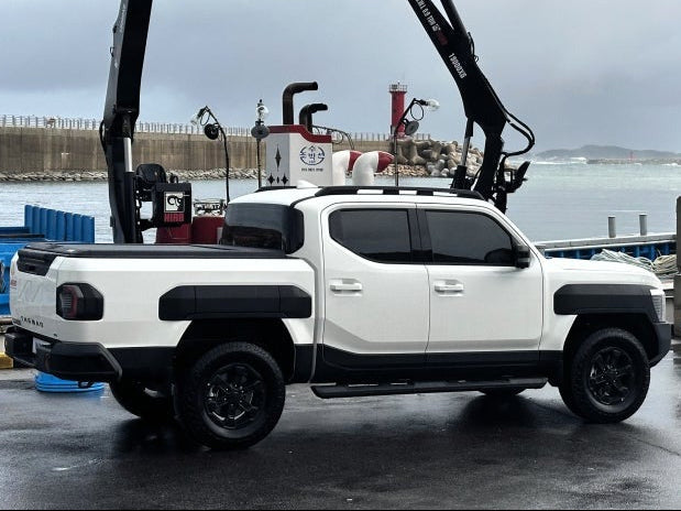 White pickup truck equipped with Kia Tasman Roller Shutter 2025+ Gen2 Manual parked at the dock.