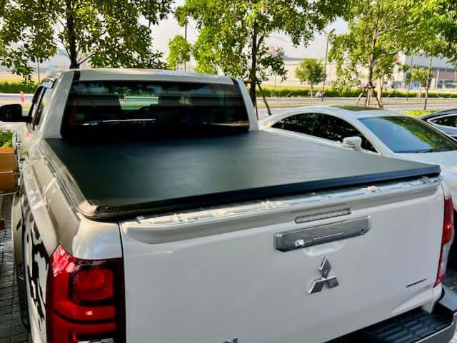Tonneau cover Triton MV Mitsubishi 2024+ Soft Roll Up by UniUte installed on a truck, offering weatherproof protection and versatility.