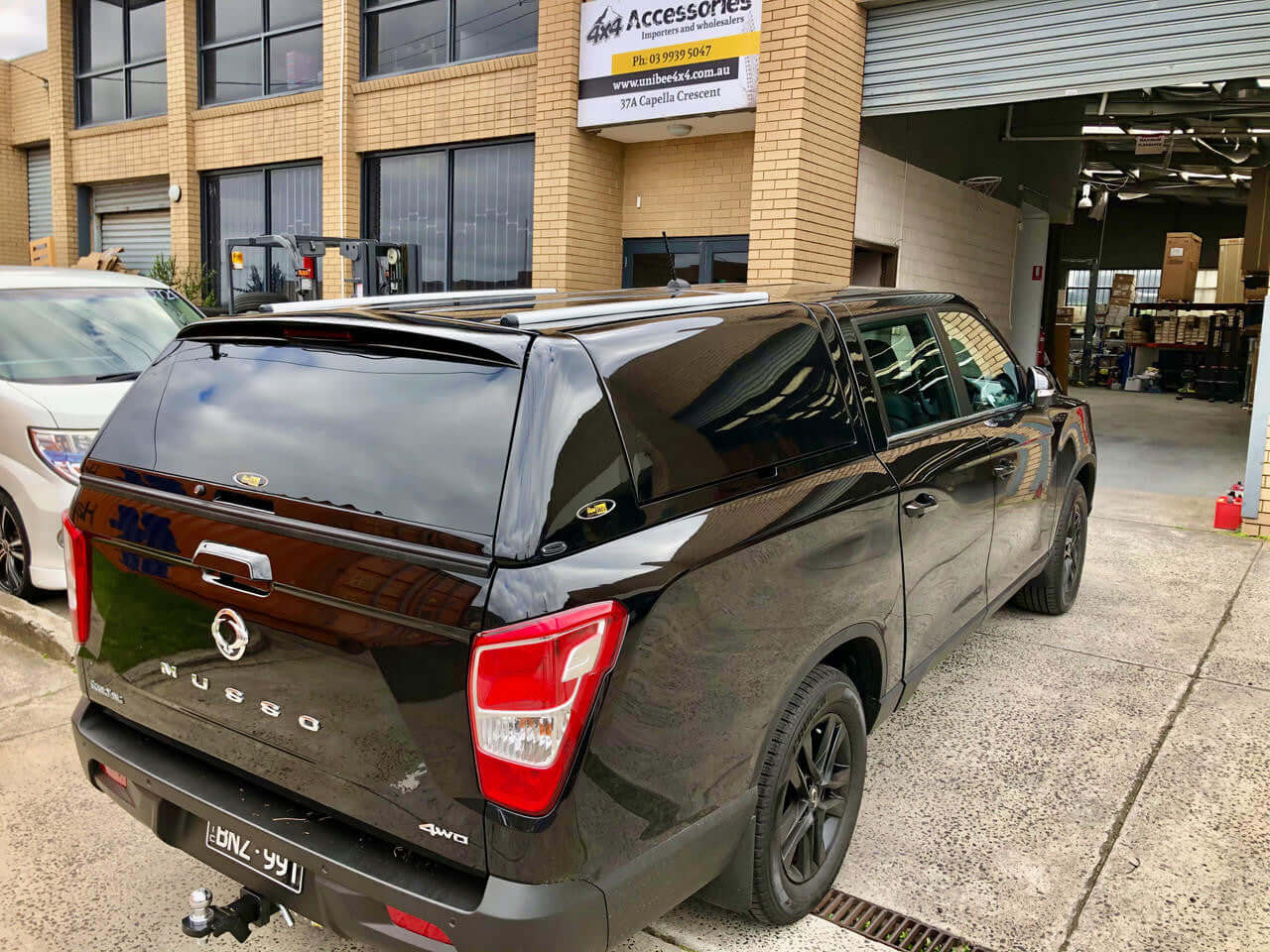 SsangYong Musso XLV Canopy FORCE PRO PLUS parked outside a workshop showcasing sleek design and premium features