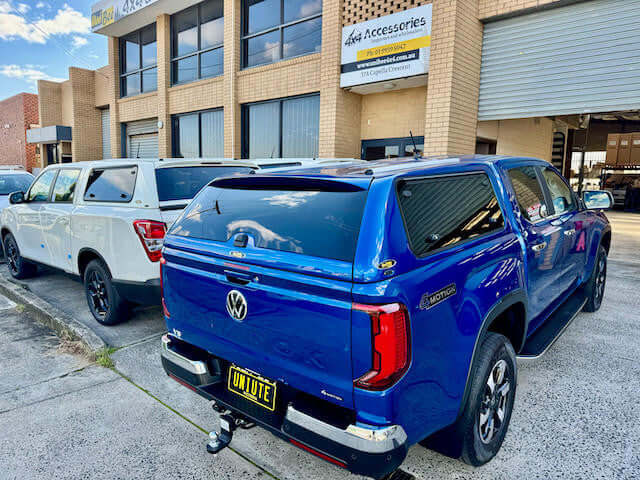 Amarok canopy FORCE PRO on blue Volkswagen Amarok 2023-2025 by UniUte parked outside accessories shop