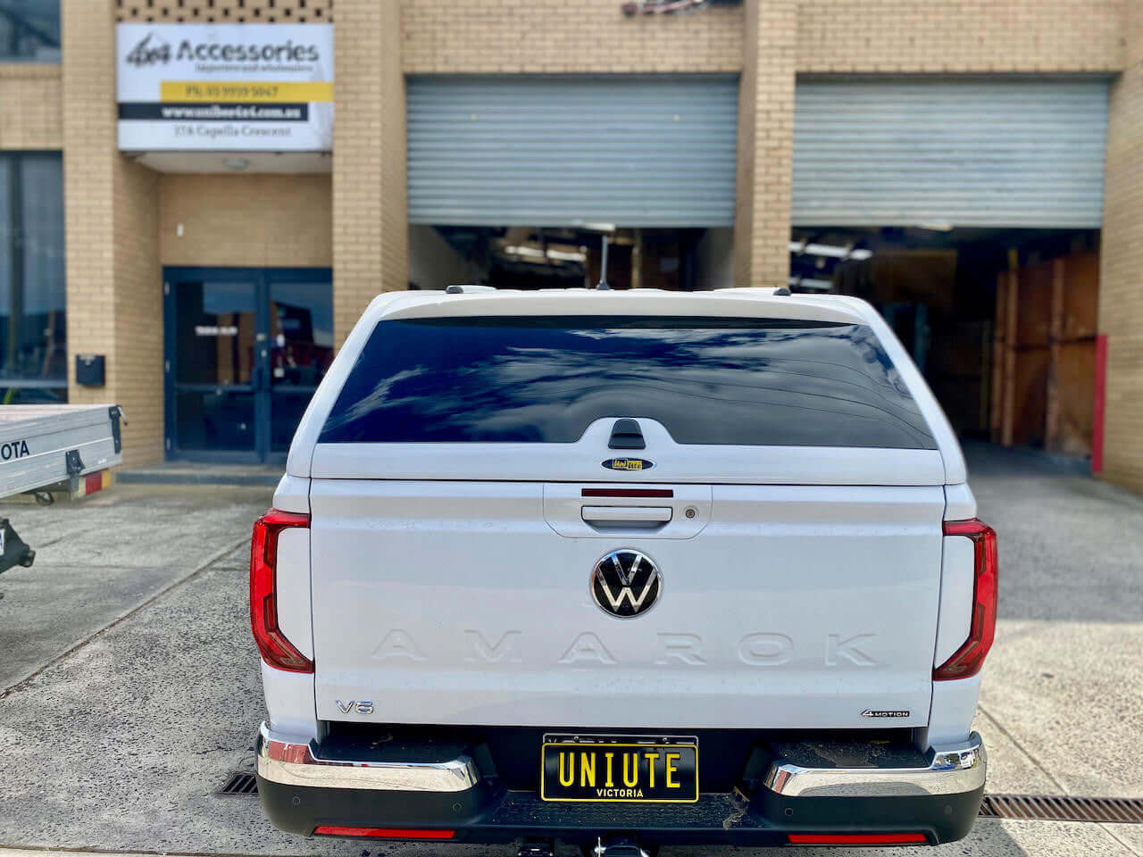 amarok canopy on Volkswagen Amarok 2023 with UniUte branding at a workshop exterior