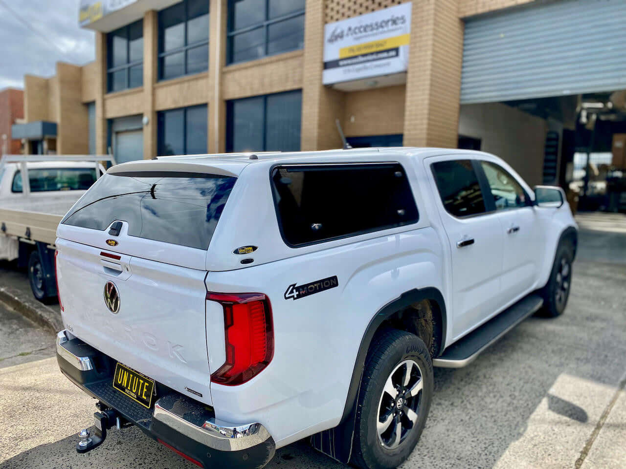 Amarok Canopy FORCE PRO on 2023 Volkswagen Amarok by UniUte, parked outside a building, showcasing the sleek design of the canopy.